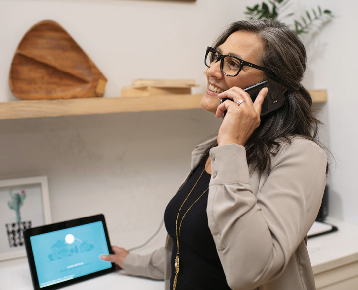Woman talking on phone with tablet