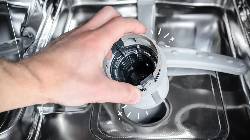 Man removing and cleaning filter inside dishwasher